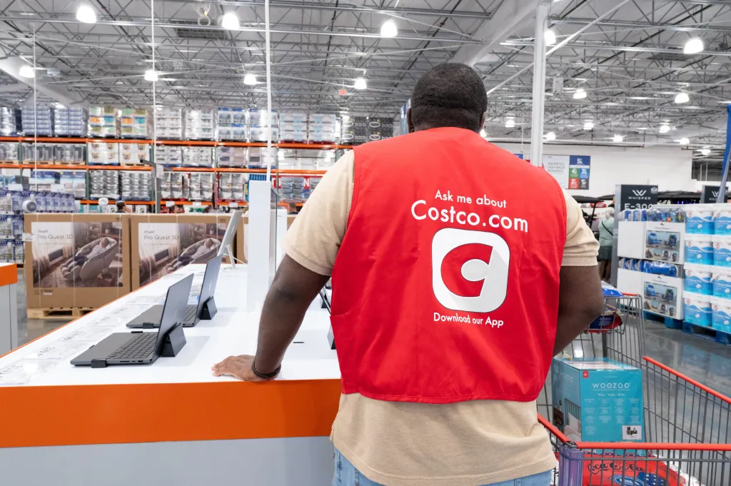 An employee in a red vest that reads 