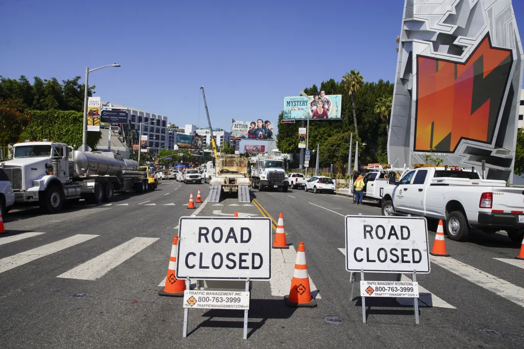 Road closed signs and traffic management vehicles on a street in West Hollywood.