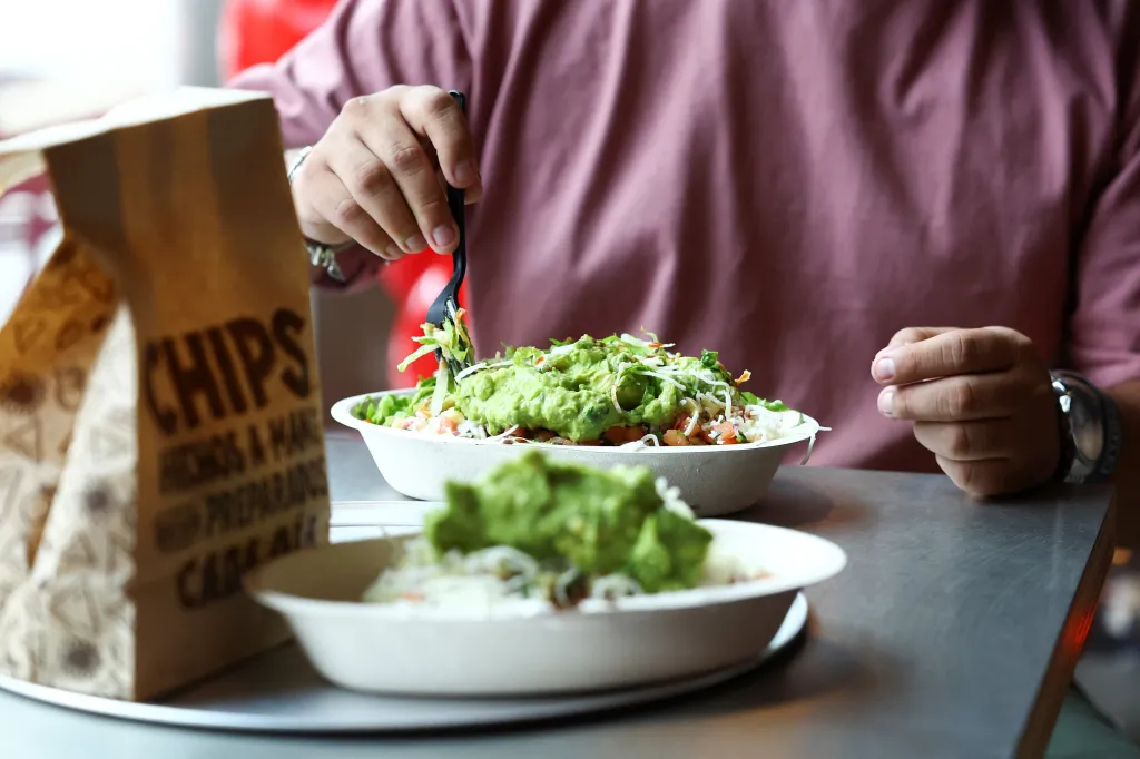 A customer eats a burrito bowl with guacamole at the first Chipotle fast-food restaurant in northeastern Mexico.