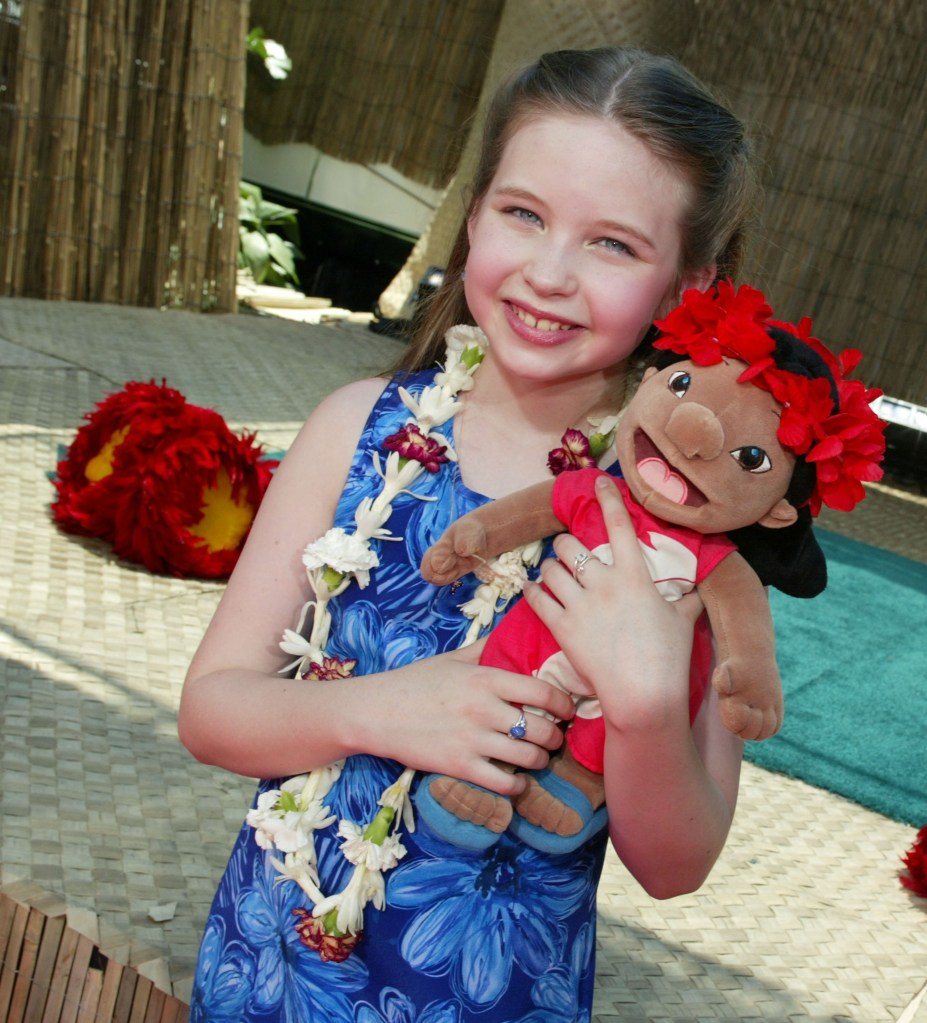 Daveigh Chase, voice of Lilo, holding a Lilo plush doll at the 