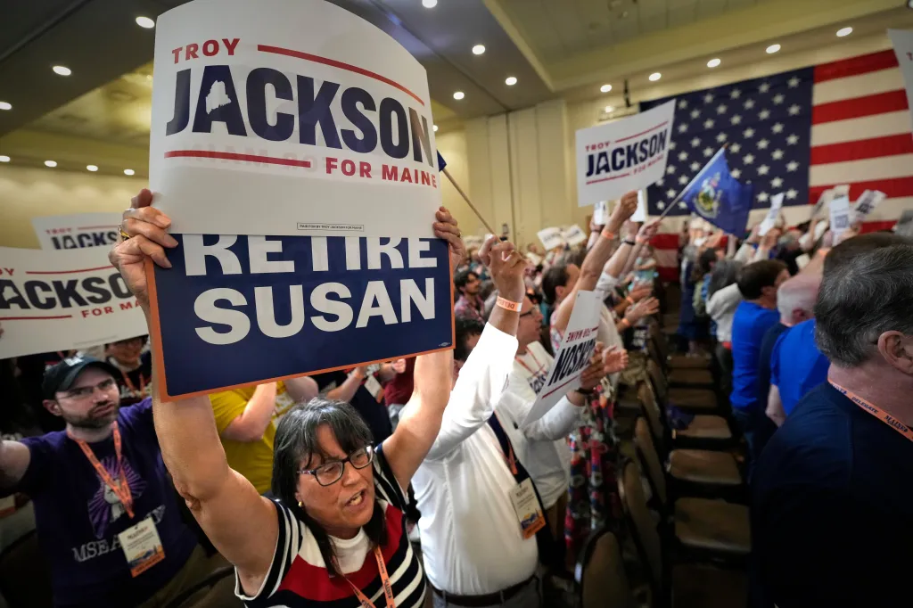Delegates at the Maine Democratic Nominating Convention cheer for Troy Jackson, holding up