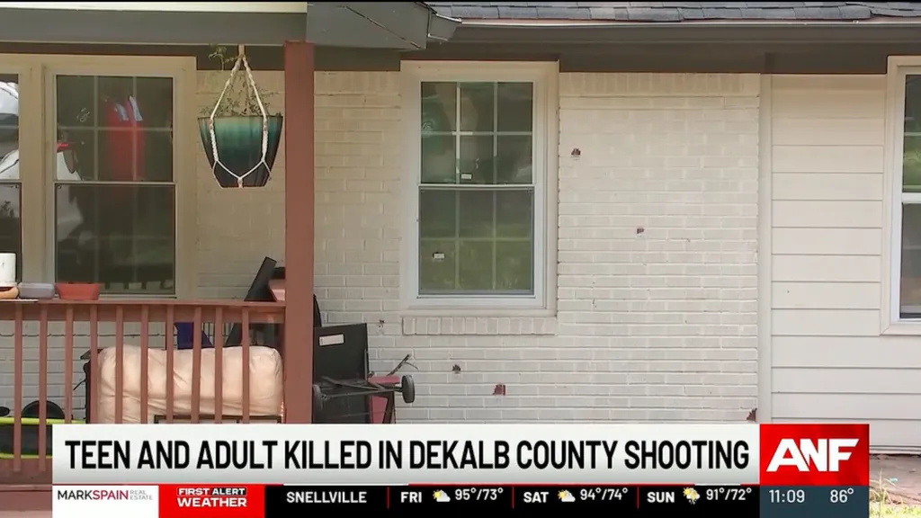 Bullet holes in the exterior of a white brick house.