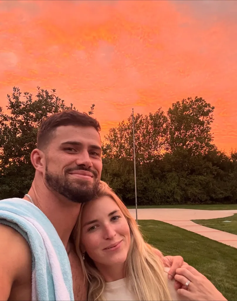 Drue and Jackie Tranquill posing together with a bright orange sunset behind them.