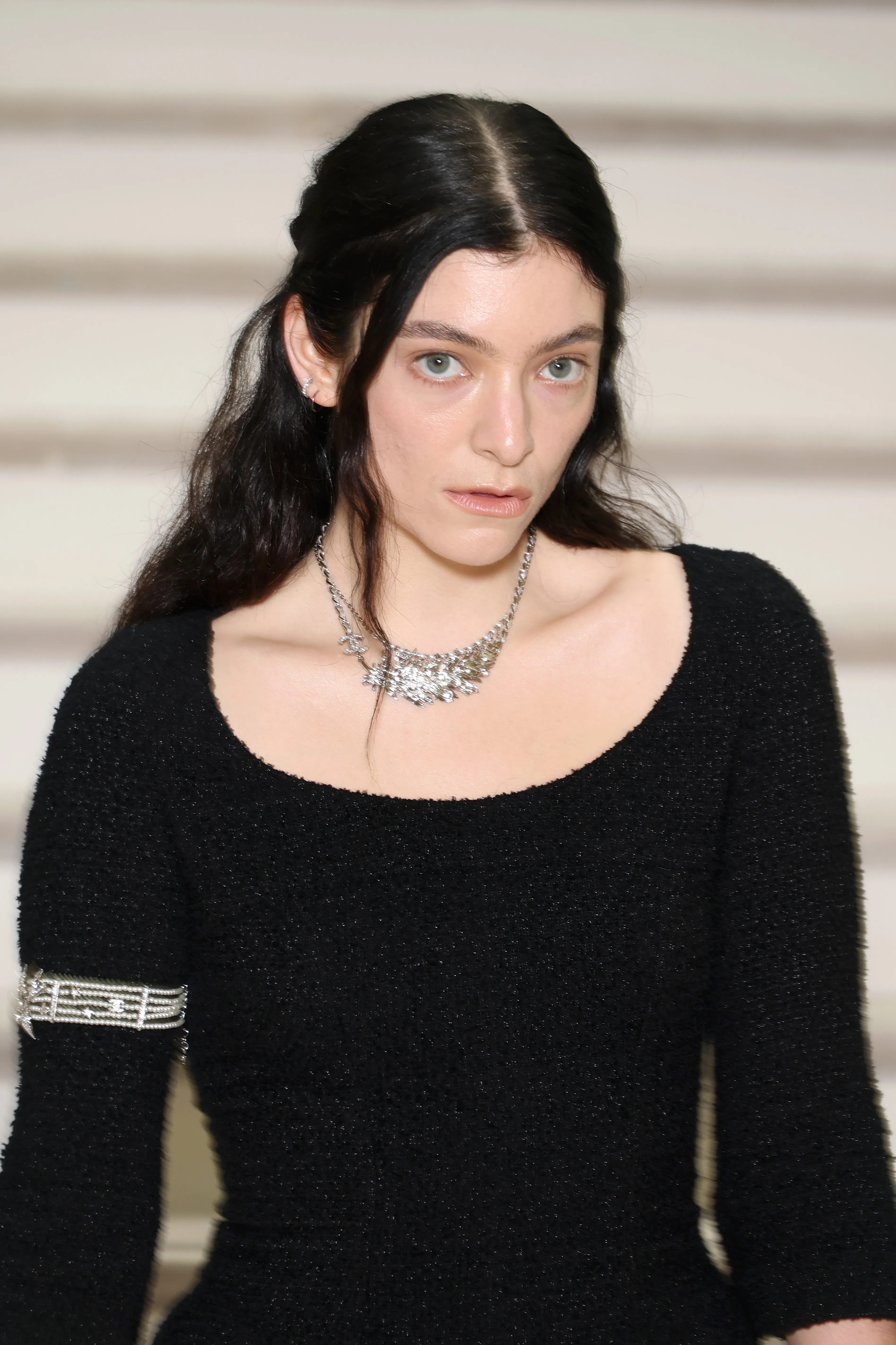 Lorde in a black knit dress and ornate silver necklace.