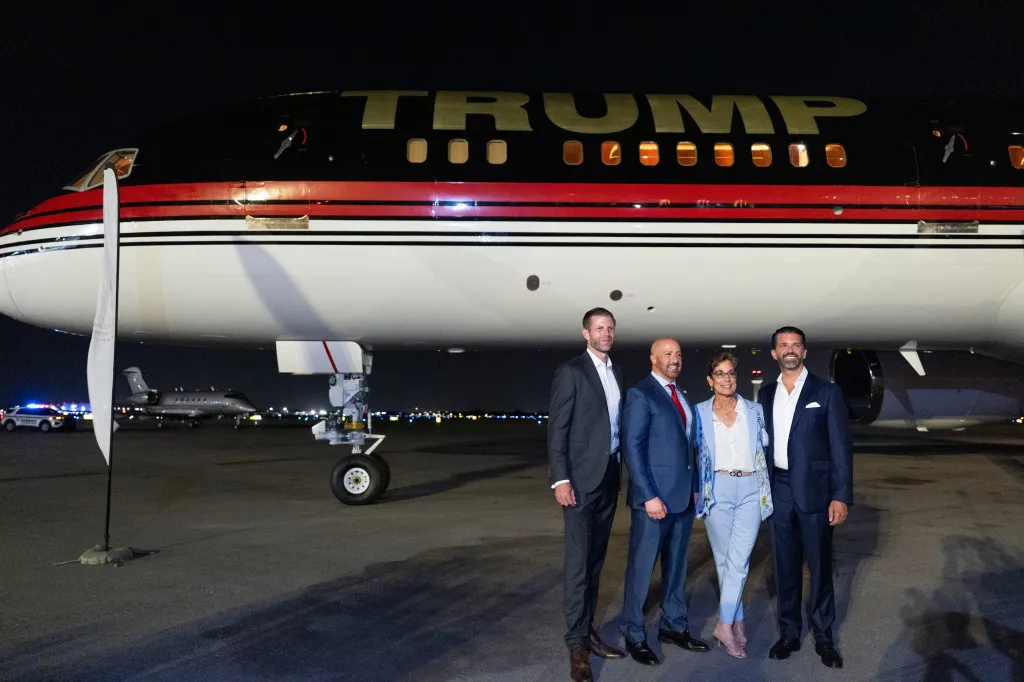 Eric Trump, Joseph Abruzzo, Maria Marino, and Donald Trump Jr. pose for a photo in front of 