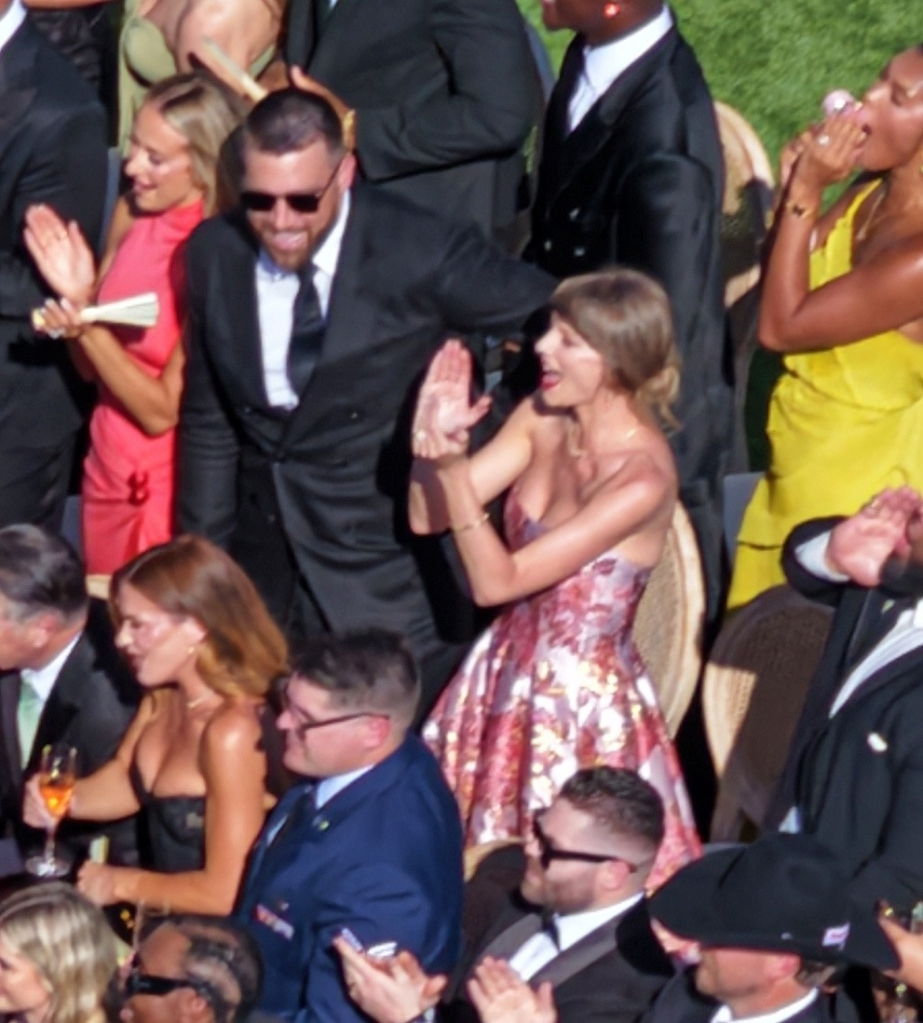 Taylor Swift and Travis Kelce clapping at Juju Smith-Schuster's wedding.
