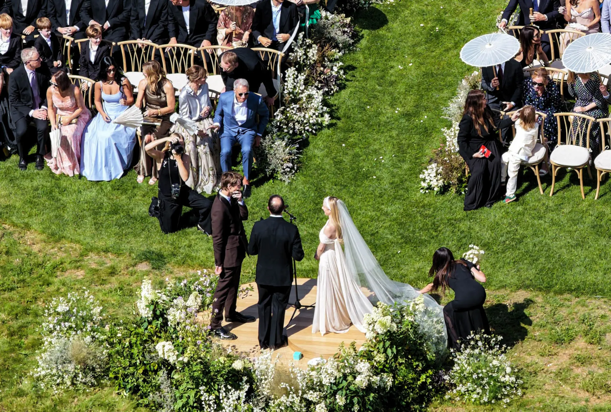 Emma Roberts and Cody John stand at their wedding ceremony with guests seated on either side.