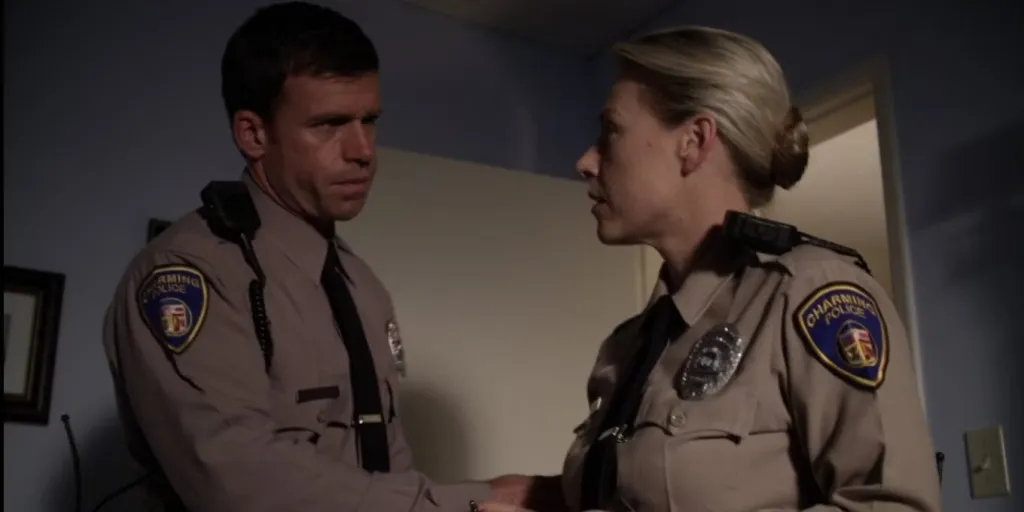 Taylor Sheridan as Deputy David Hale and a female officer wearing Charming Police uniforms.