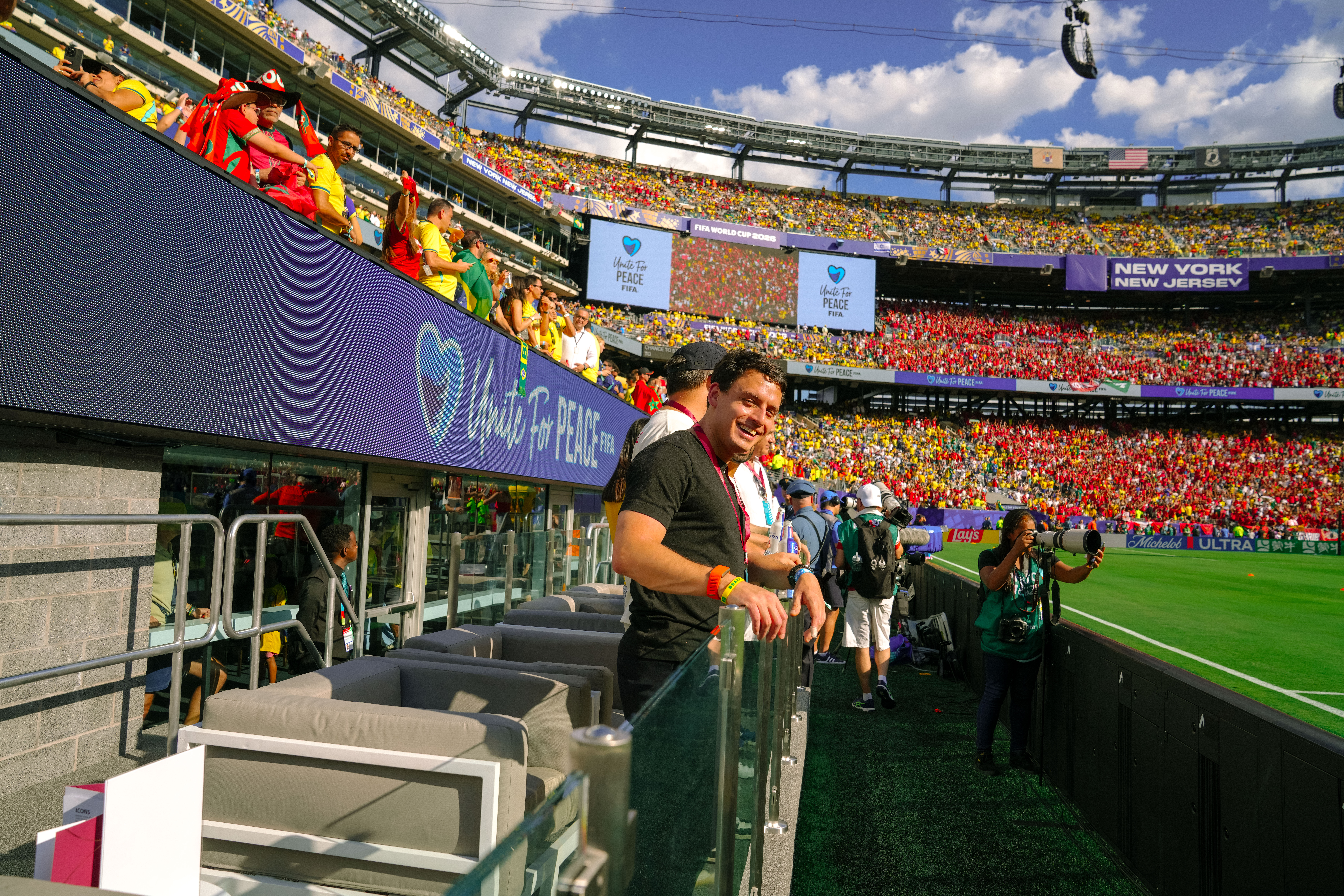 People in FIFA World Cup 2026 suites looking at the soccer field and crowd.