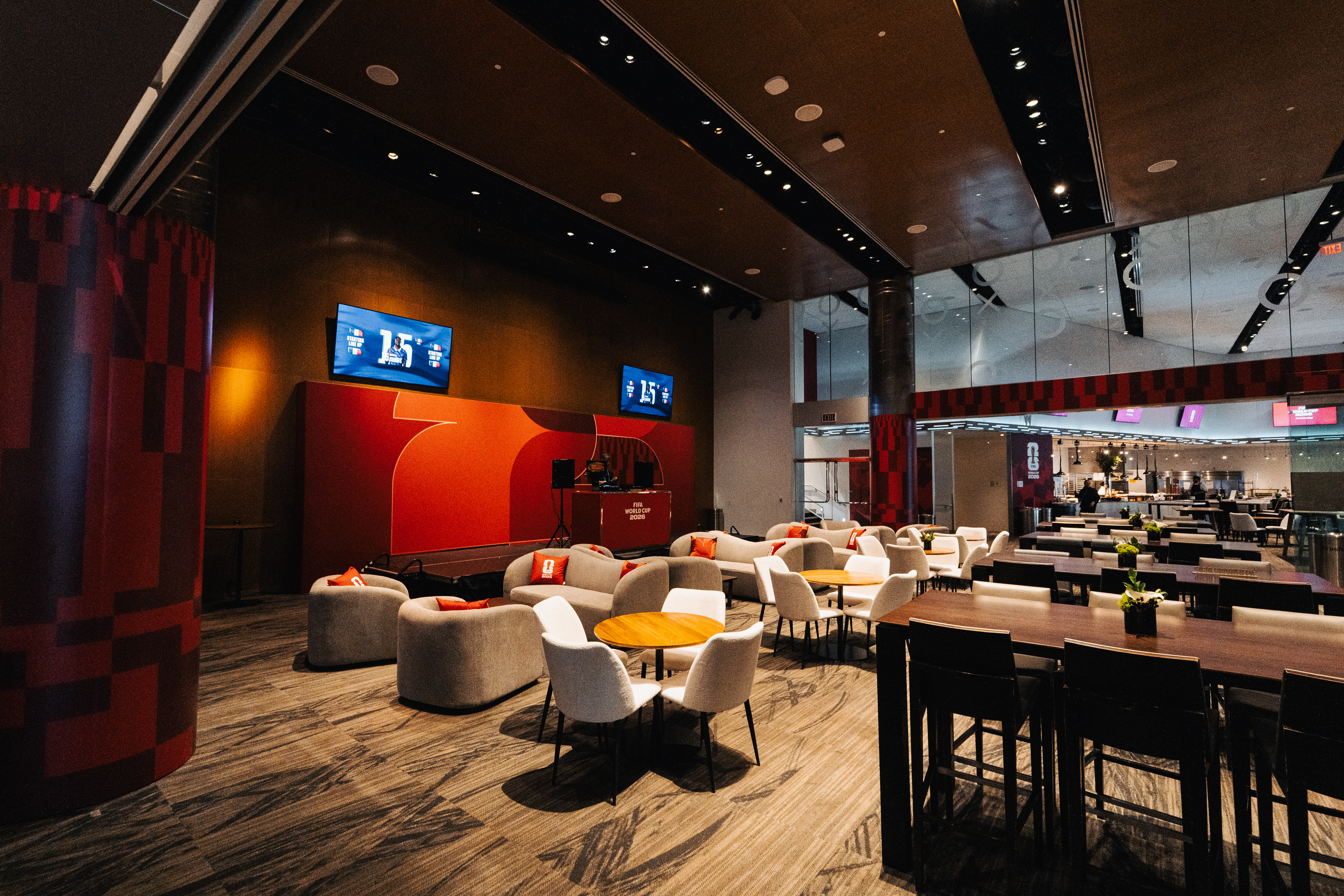 An empty lounge area with couches, tables, and screens displaying FIFA World Cup 2026 branding.