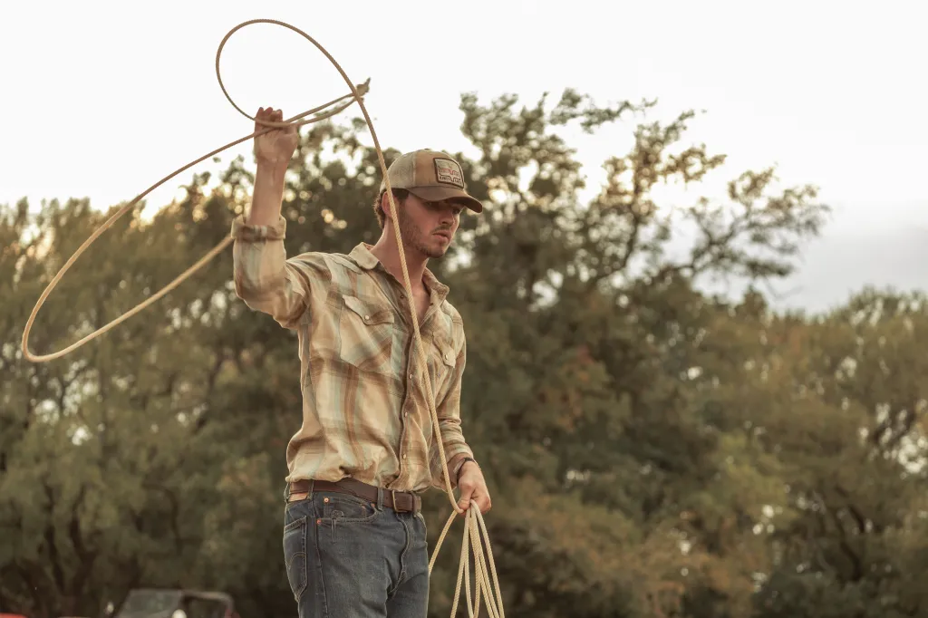 Finn Little as Carter holding a lasso on Dutton Ranch.