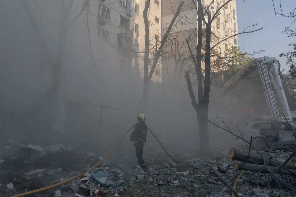 A firefighter works at a residential building struck by a Russian missile in Kyiv.