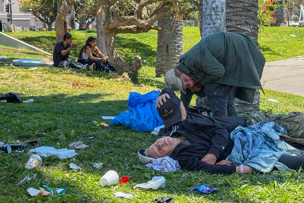 People experiencing homelessness resting and interacting in MacArthur Park.