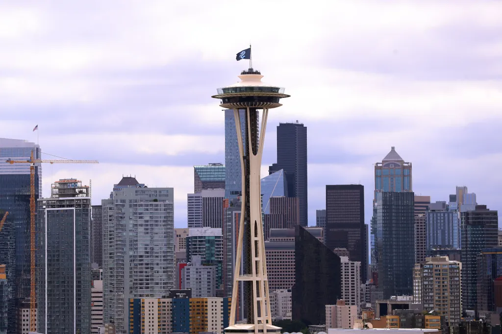 The Space Needle in Seattle with a Seattle Kraken flag flying from its top.