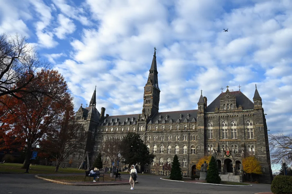 Georgetown University's main building, Healy Hall, with students and fall foliage.