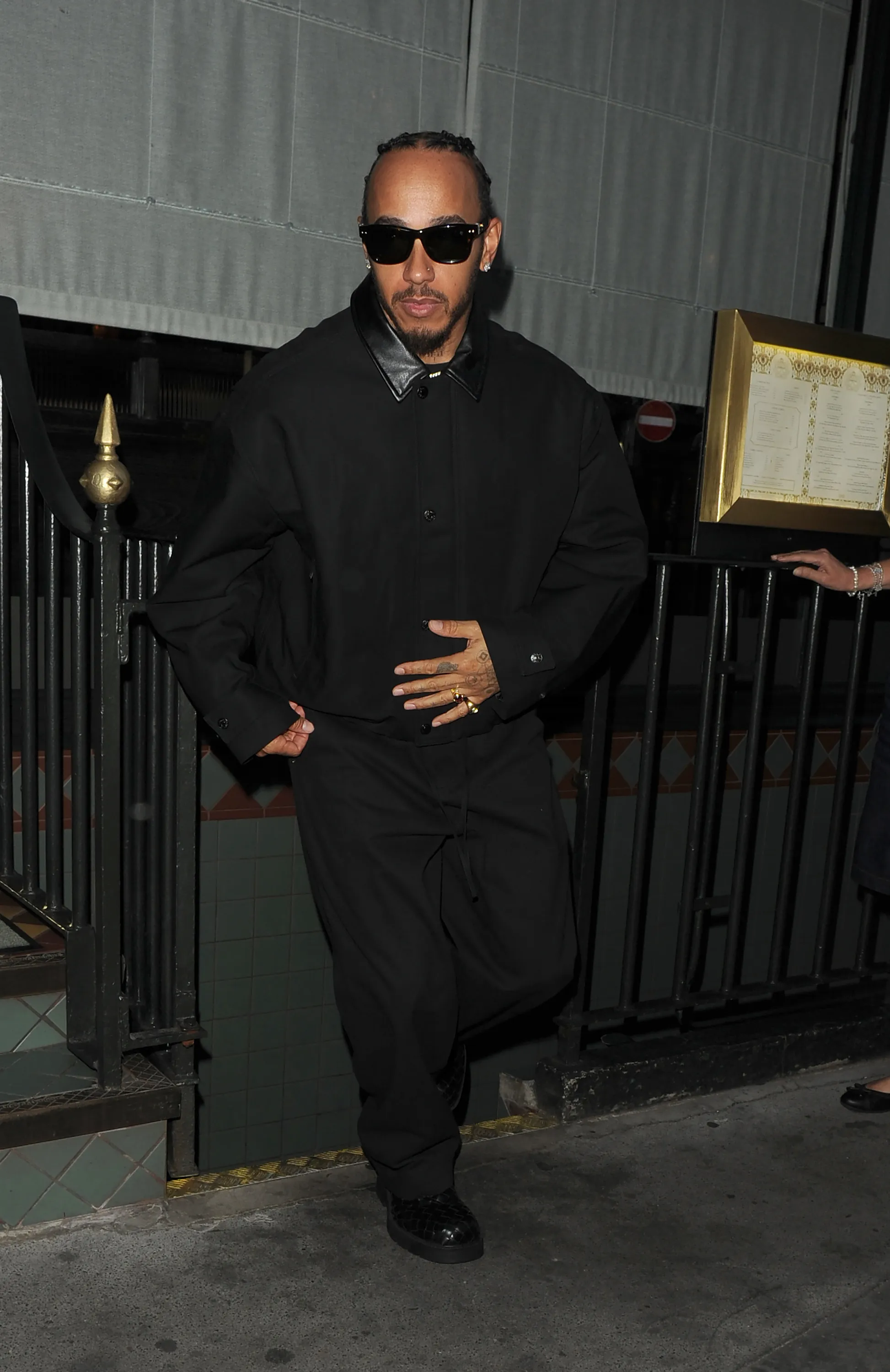Lewis Hamilton in a black oversized utility shirt and baggy black trousers.