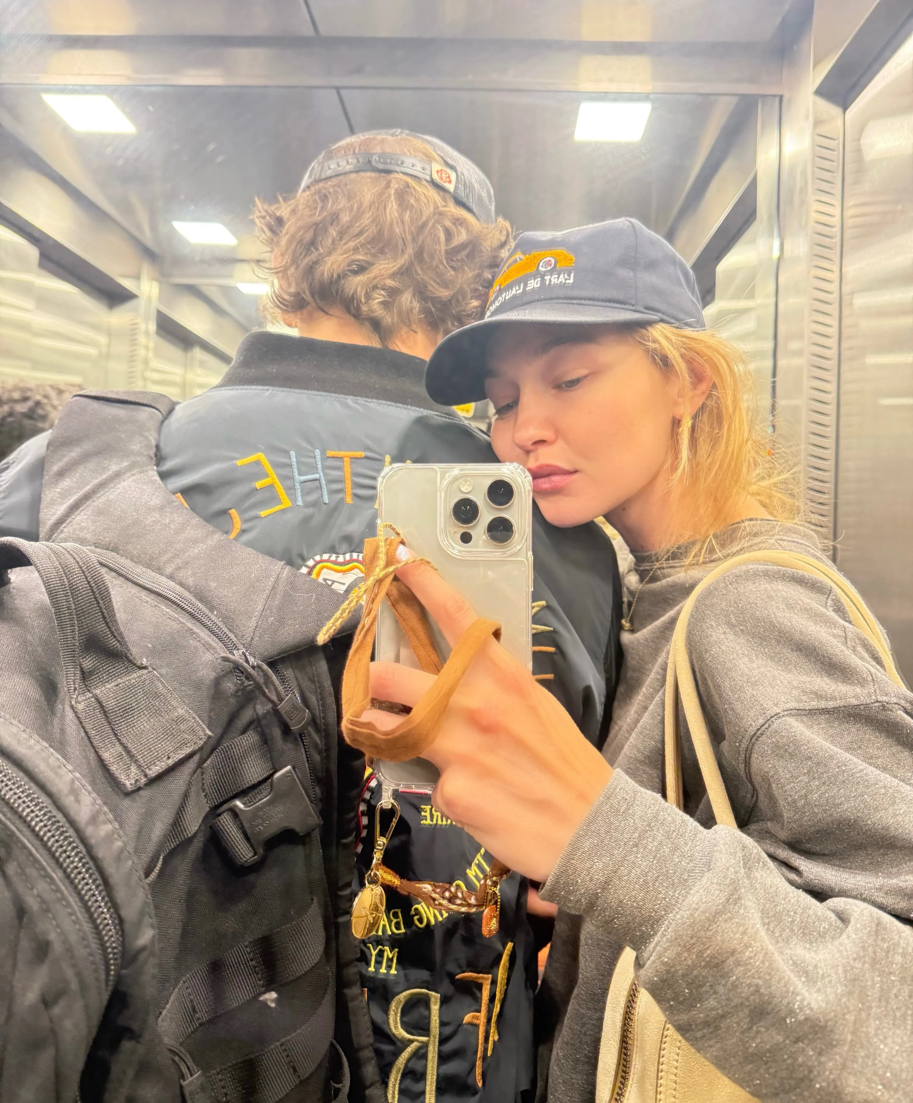 Gigi Hadid taking a mirror selfie with Bradley Cooper in an elevator.