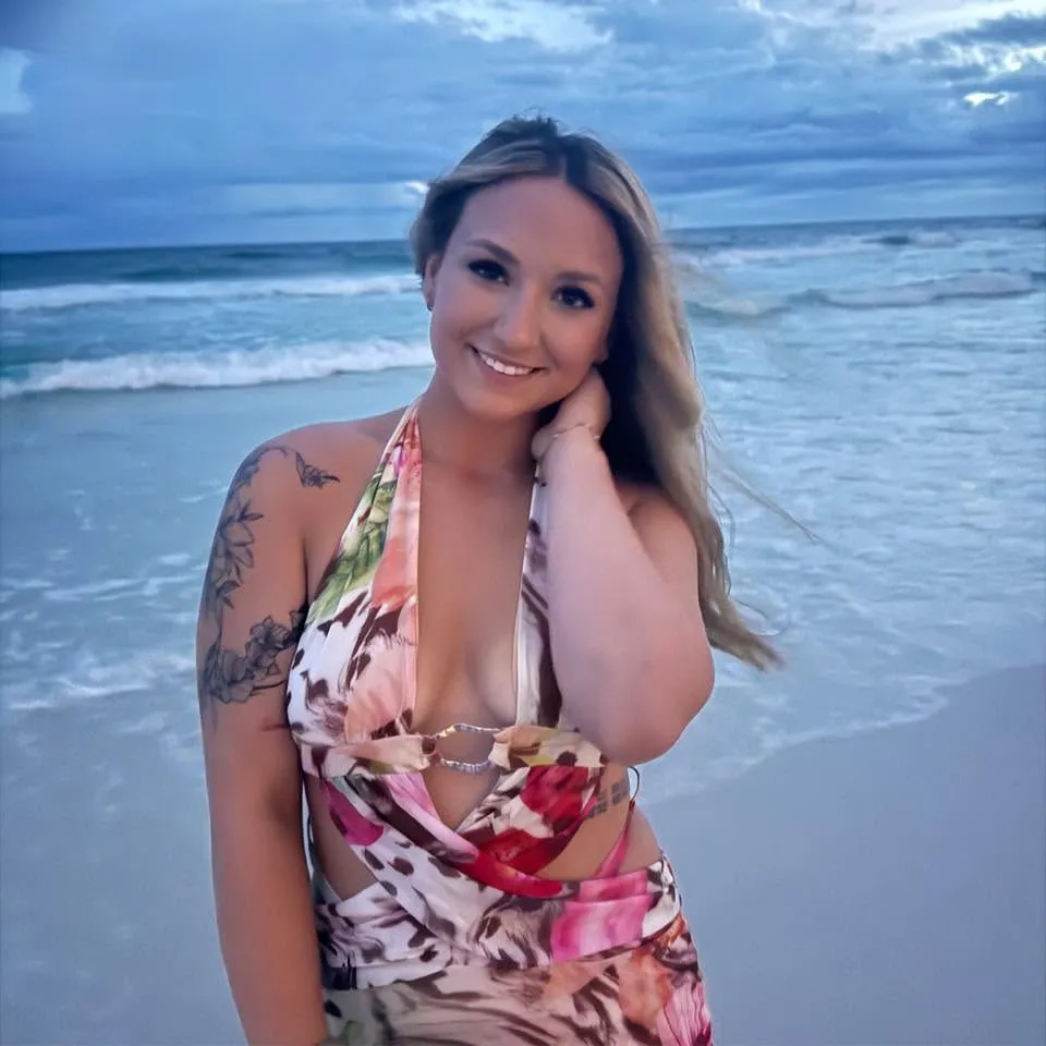 Katie McCormack smiling on a beach.