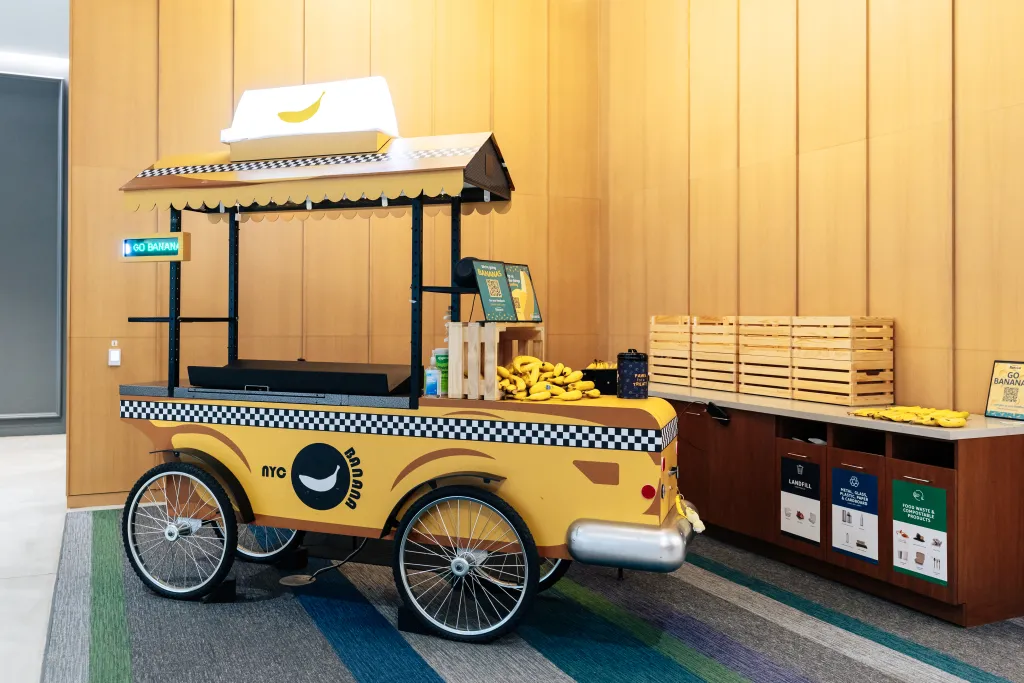 A banana stand designed like a yellow NYC taxi cab, with a digital 