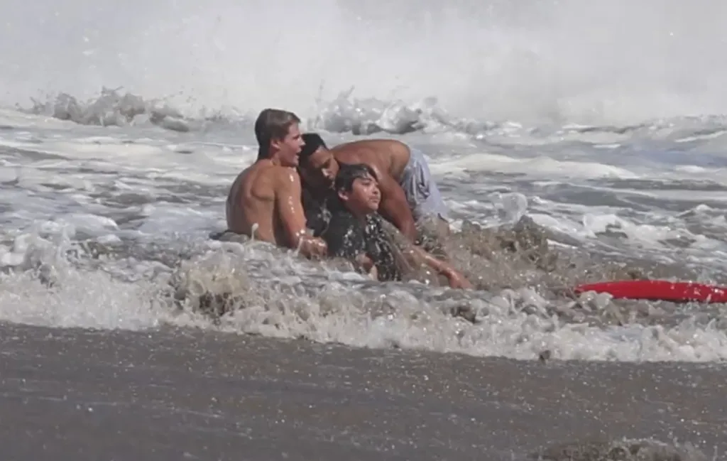 Lifeguards rescue a boy from a large wave off Santa Cruz.