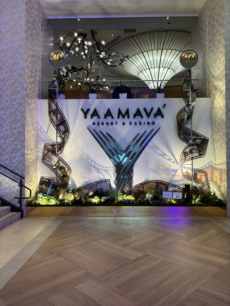 A decorative display for Yaamava’ Resort & Casino's 40th anniversary, featuring the resort logo, large film reels with images, and glowing foliage.