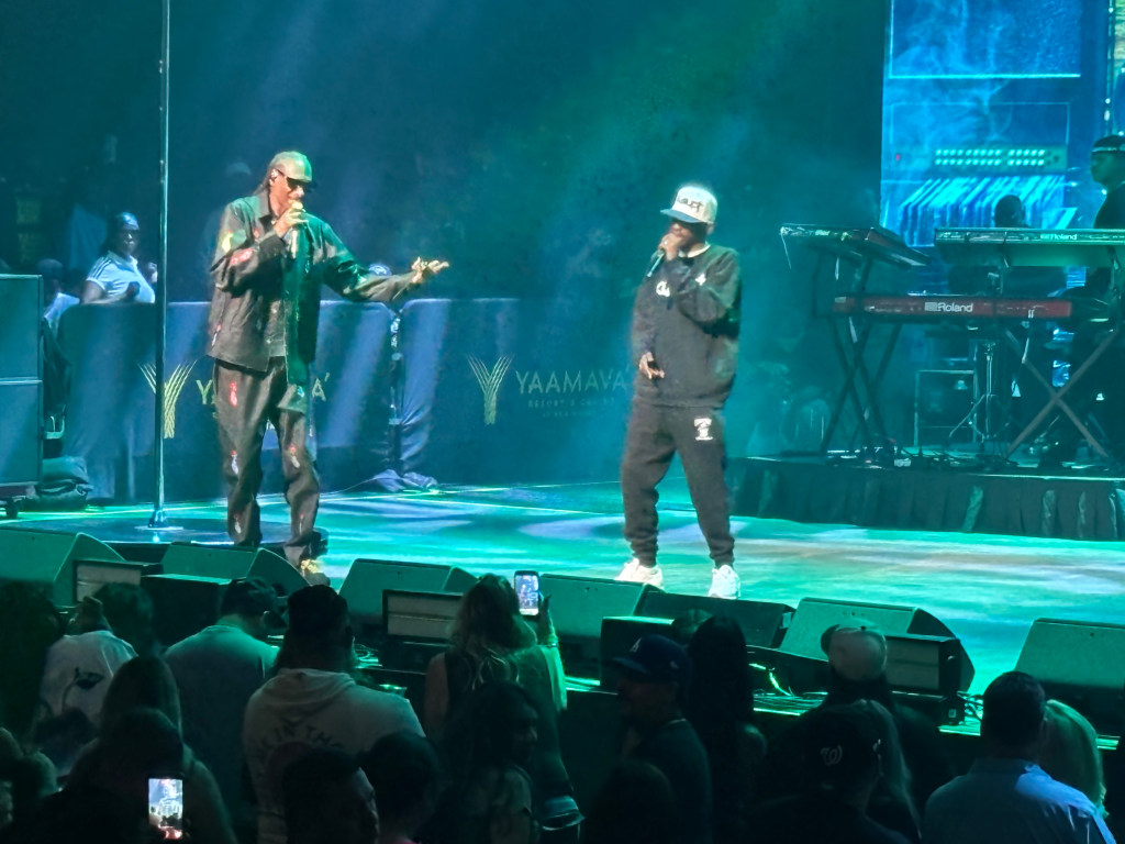 Snoop Dogg performing with another artist on stage, with a 