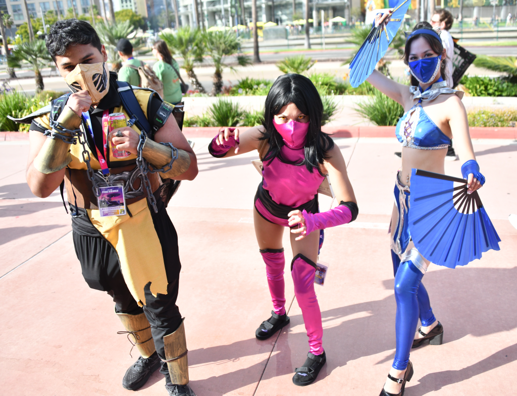 Three people cosplay as Scorpion, Mileena, and Kitana from Mortal Kombat.