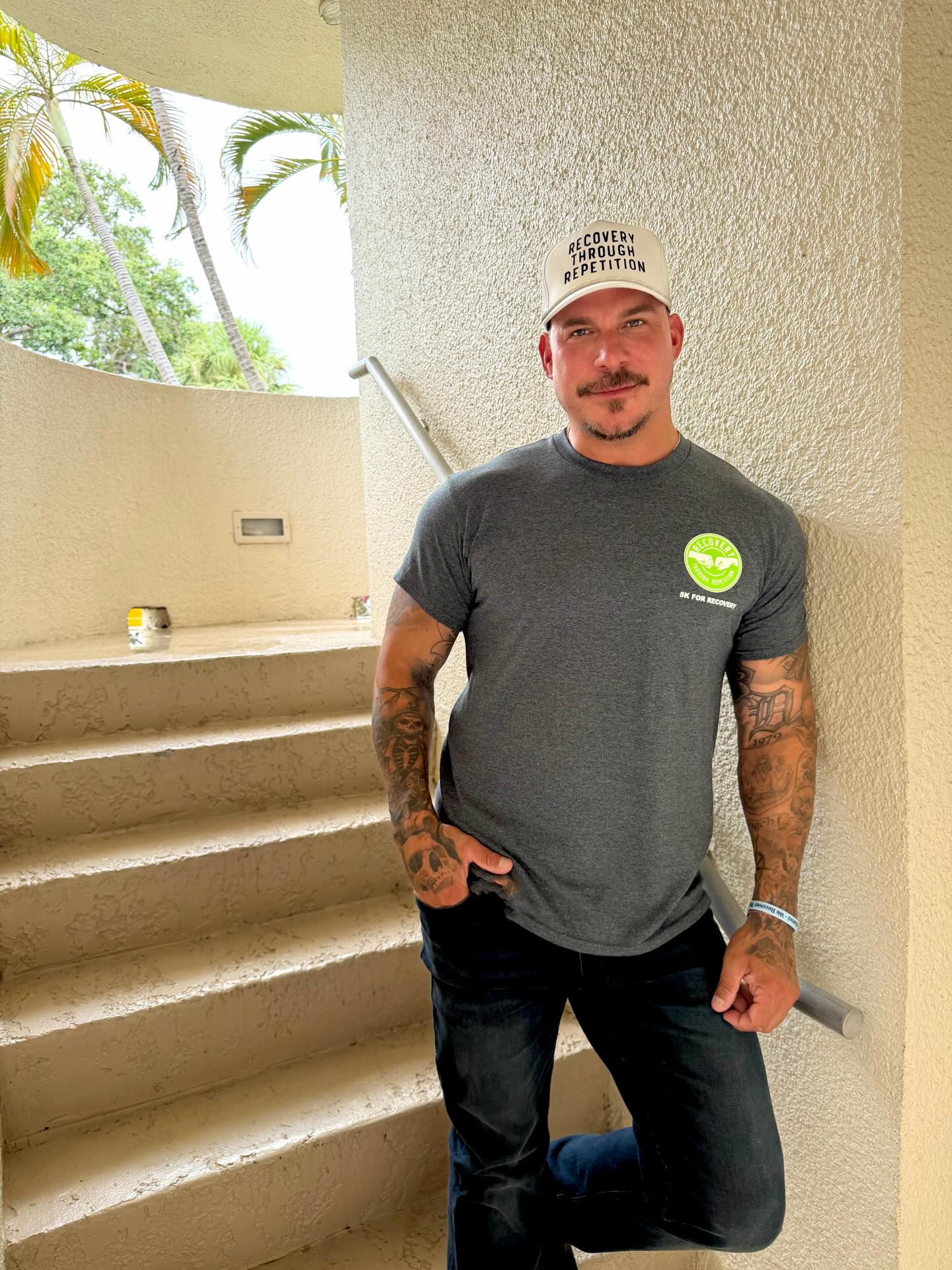 Jax Taylor in a gray t-shirt and a white hat that says 