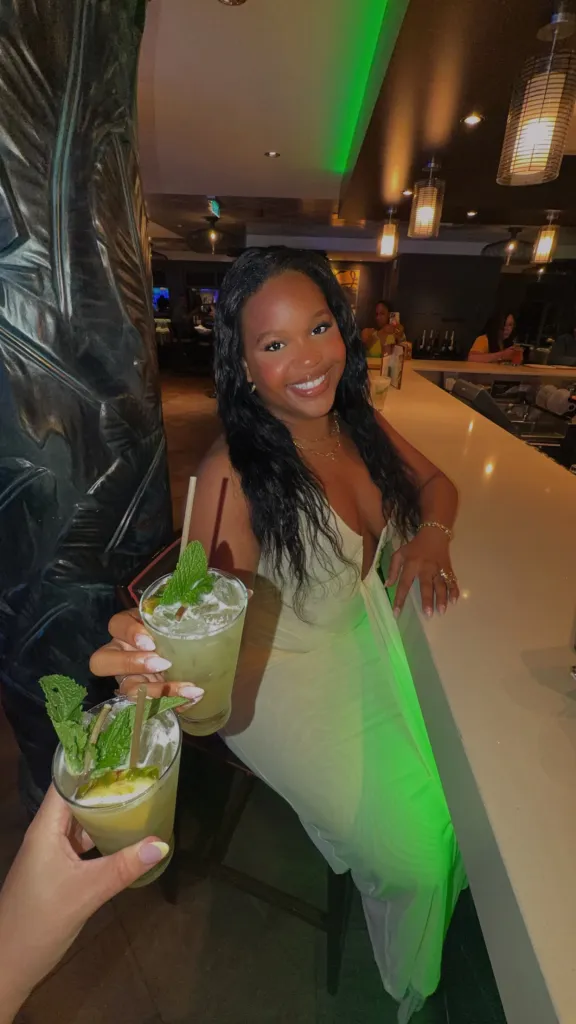 Jazmine Alexis Bates holding a mojito in a bar.