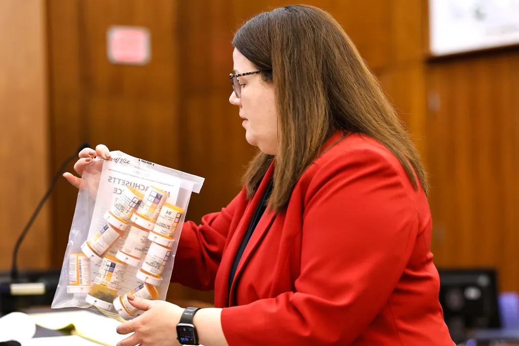 Prosecutor Jennifer Sprague presenting a bag of prescription pills as evidence in a trial.