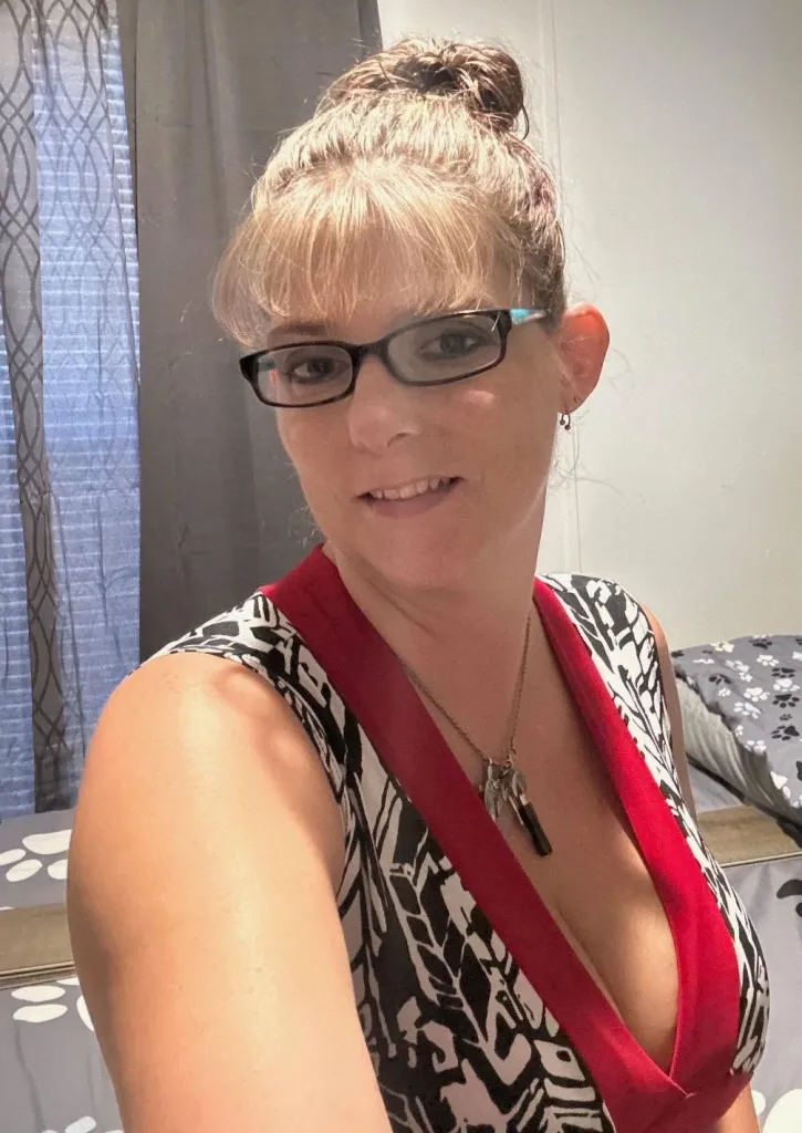 Jessica Folds, wearing glasses and a patterned top.