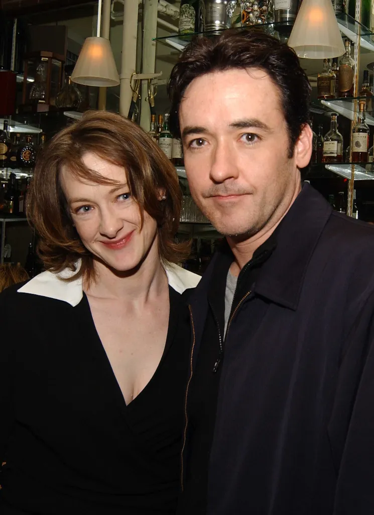 Joan and John Cusack pose for a photo at a party.