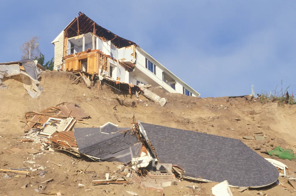 A damaged house is partially fallen down a hill after the Northridge earthquake.