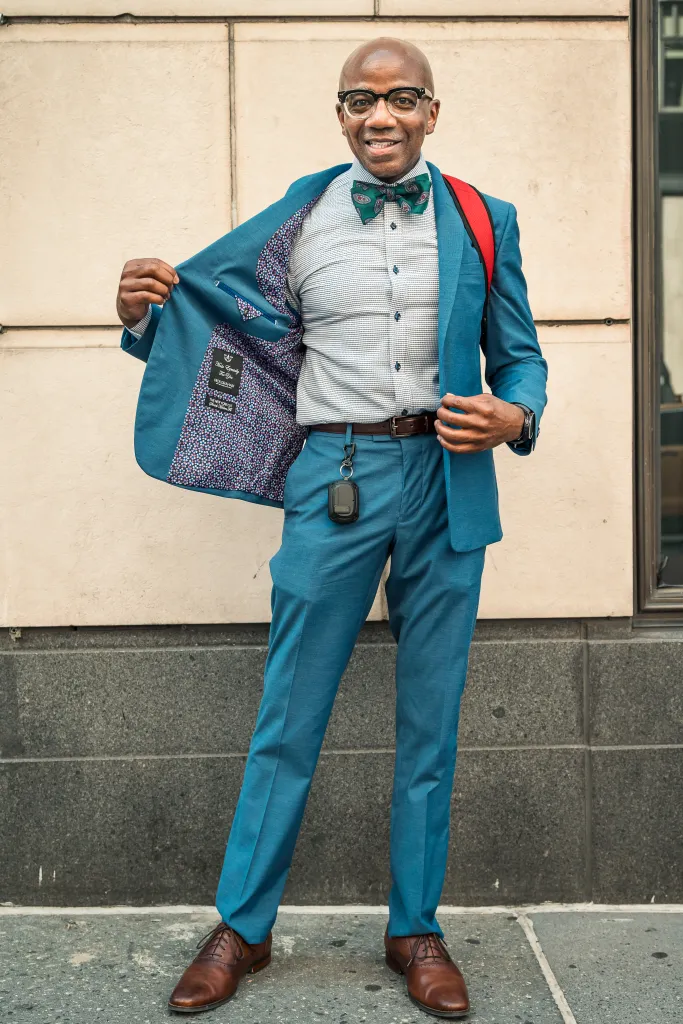 John Flowers in a teal suit, patterned shirt, and bow tie during a heat wave in NYC.