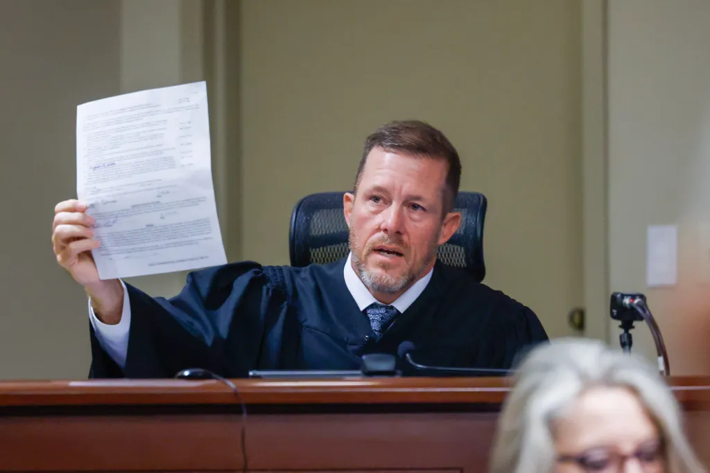 Judge Nicholas Primm holding up a plea document in court.