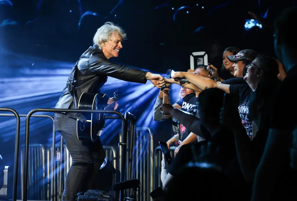 Jon Bon Jovi performing onstage and reaching out to fans at Madison Square Garden.