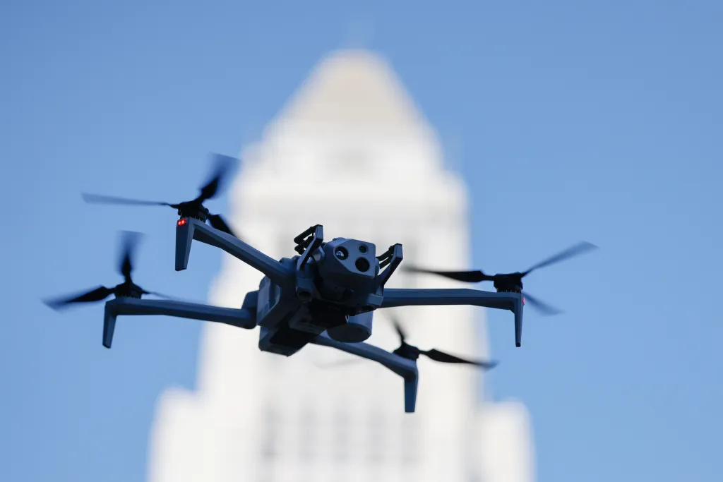 A LAPD drone in the air in front of a blurred building.