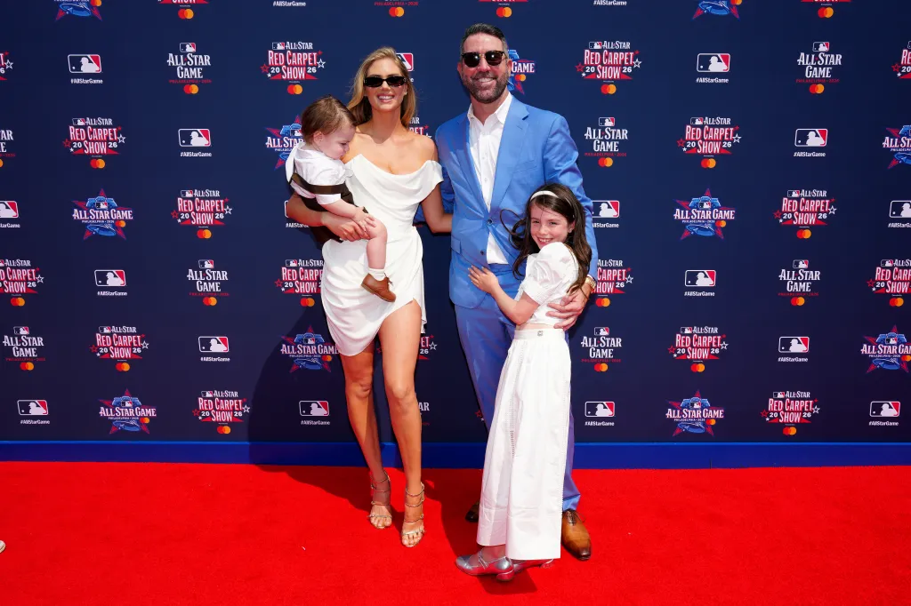 Justin Verlander, in a blue suit, poses with his wife Kate Upton, in a white off-the-shoulder dress, and their two children at the All-Star Red Carpet Show.