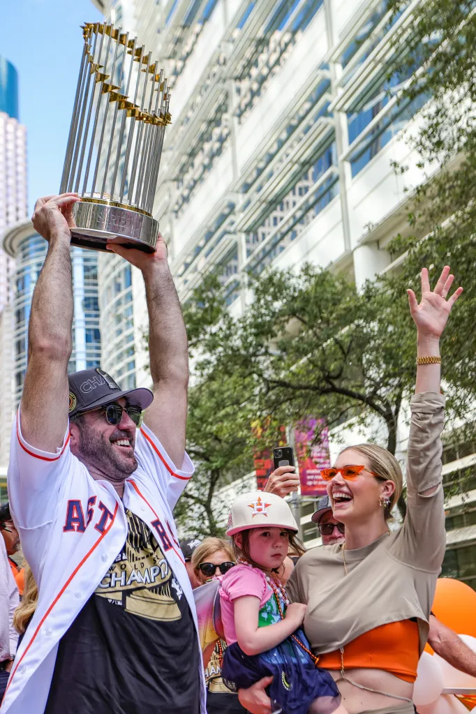 Justin Verlander holding up the World Series trophy with Kate Upton and their daughter at the Houston Astros World Series Parade.