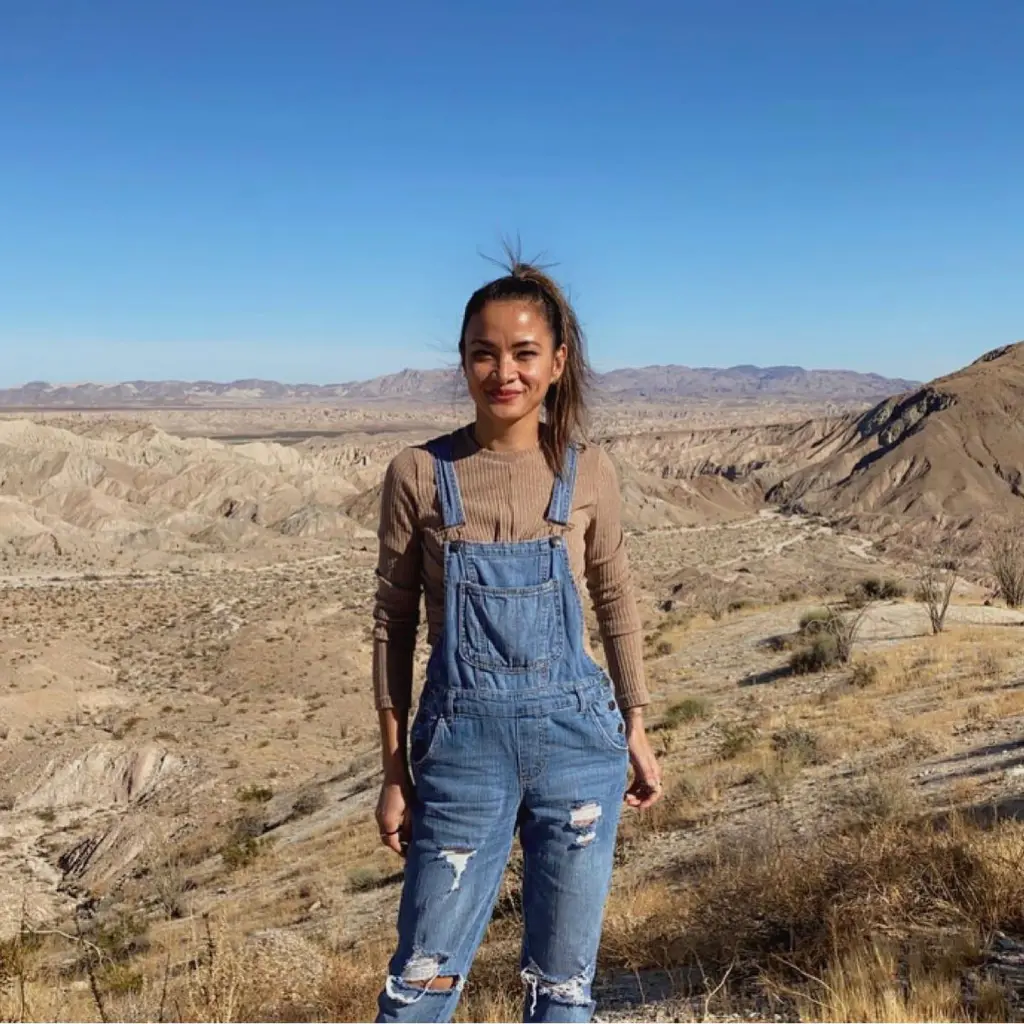 Maya Millete smiling in a desert landscape.
