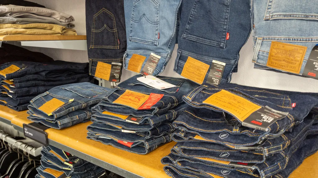 Levi's jeans in various washes and styles displayed on shelves in a store.