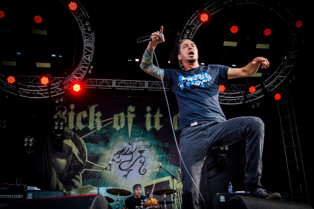 Lou Koller of Sick of it All performing on stage with a microphone.