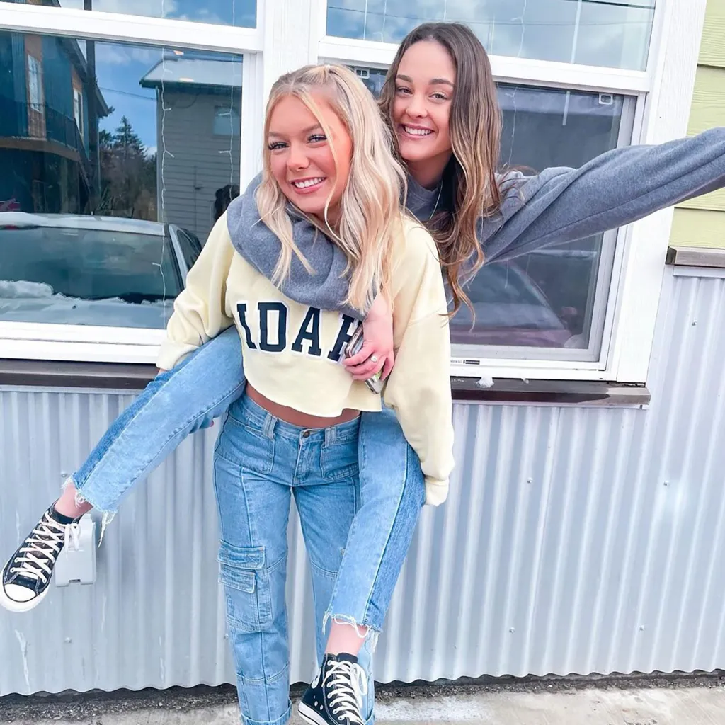 Madison Mogen (left) giving Xana Kernodle (right) a piggyback ride, both smiling at the camera.