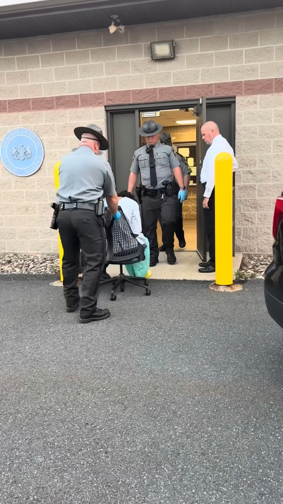 Troopers drag Michael Bon out of a police outpost after his arrest. 