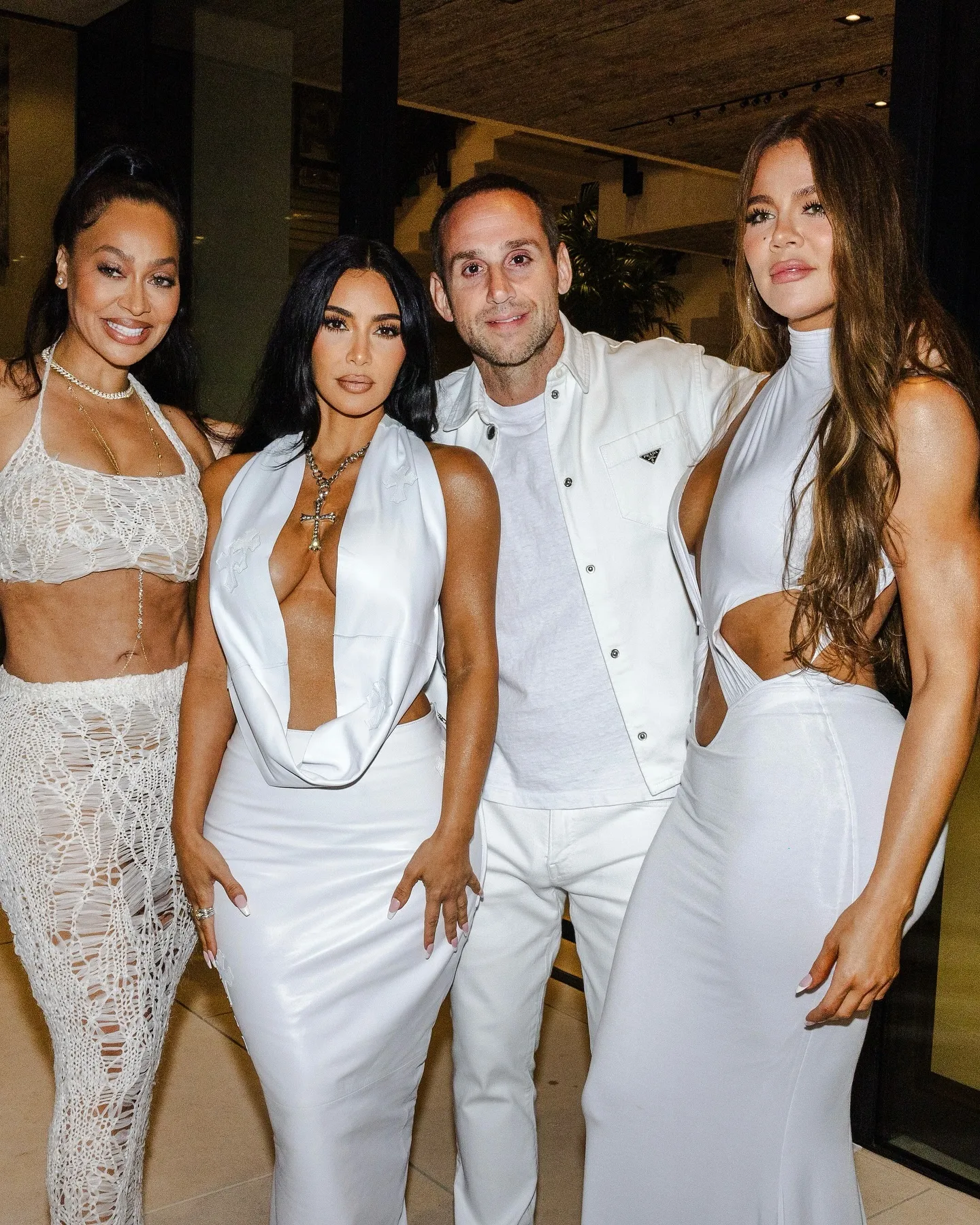 Lala Anthony, Kim Kardashian, Michael Rubin, and Khloe Kardashian posing together in white outfits.