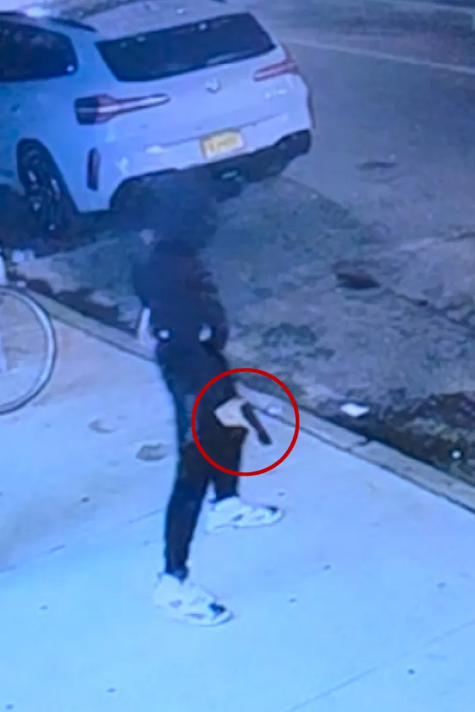 A security camera image showing an 18-year-old gunman loading a 9mm handgun.