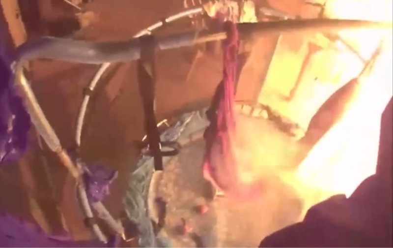 Image from inside a burning house, showing flames and smoke.