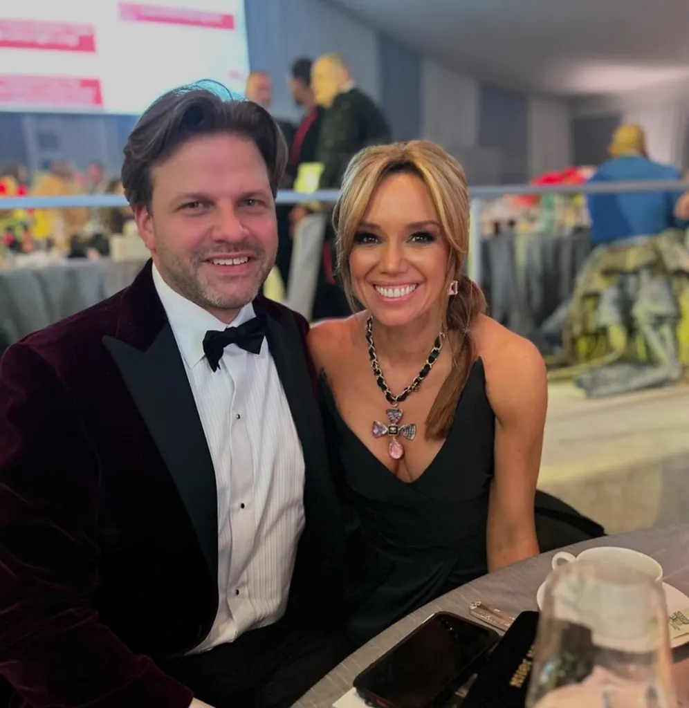Sara Gore smiles beside a man in a tuxedo.