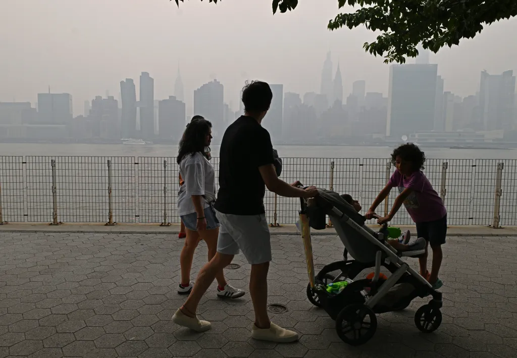New Yorkers out with their families, friends, and pets go about their lives as they navigate the smoked filled air.