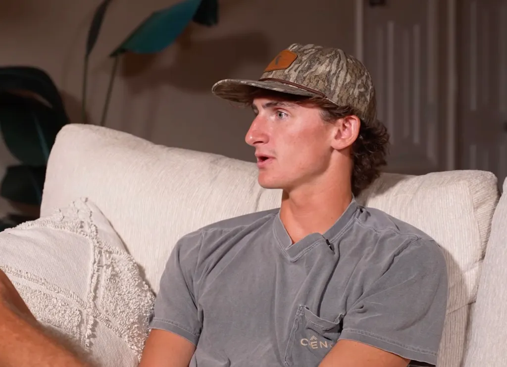 Nolan Wells' best friend Warren Hudson sitting on a couch.